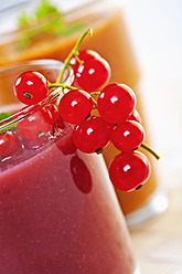 Nahaufnahme eines Smoothies aus roten Beeren und Aprikosen mit Johannisbeeren und Minze - TSF000325