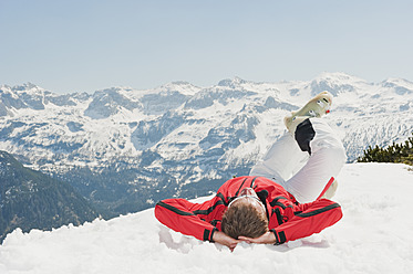 Österreich, Salzburger Land, Altenmarkt-Zauchensee, Mittlerer erwachsener Mann im Schnee liegend im Winter - HHF003751