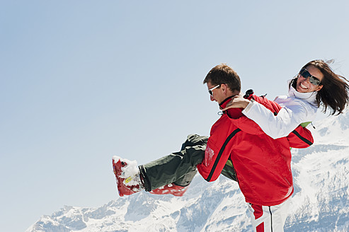 Österreich, Salzburger Land, Altenmarkt-Zauchensee, Mittlerer Erwachsener Mann trägt Frau im Winter - HHF003753