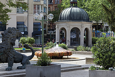 Europa, Deutschland, Hessen, Wiesbaden, Kochbrunnenplatz, Blick auf heißen Thermalbrunnen mit Springbrunnen und Löwenstatue im Vordergrund - CSF015370