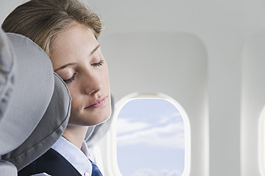 Deutschland, Bayern, München, Nahaufnahme einer jungen Stewardess, die in der Business Class eines Flugzeugs schläft - WESTF016815