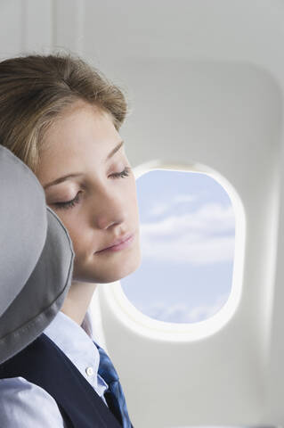 Deutschland, Bayern, München, Nahaufnahme einer jungen Stewardess, die in der Business Class eines Flugzeugs schläft, lizenzfreies Stockfoto