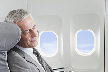 Deutschland, Bayern, München, Älterer Geschäftsmann schläft in der Business-Class-Kabine eines Flugzeugs - WESTF016817