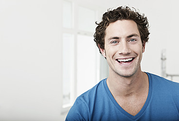 Germany, Cologne, Close up of young man in renovating apartment, smiling, portrait - FMKF000318