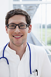 Deutschland, Bayern, Diessen am Ammersee, Nahaufnahme eines jungen Arztes mit Stethoskop, lächelnd, Porträt - JRF000175
