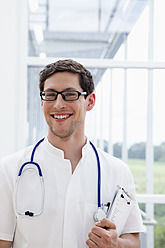 Deutschland, Bayern, Diessen am Ammersee, Nahaufnahme eines jungen Arztes mit Stethoskop, lächelnd, Porträt - JRF000177