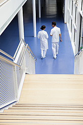 Deutschland, Bayern, Diessen am Ammersee, Zwei junge Ärzte beim Spazierengehen und Diskutieren im Erdgeschoss - JRF000200