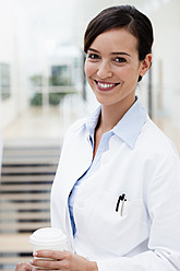 Germany, Bavaria, Diessen am Ammersee, Young doctor with disposable cup, smiling, portrait - JRF000205