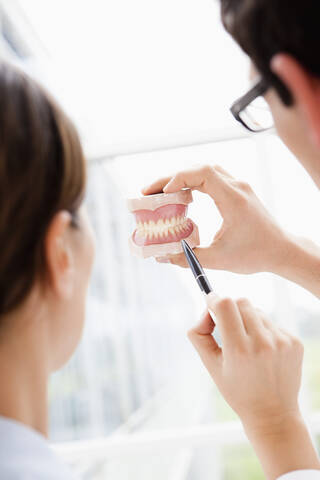 Germany, Bavaria, Diessen am Ammersee, Two young doctors examining dentures stock photo