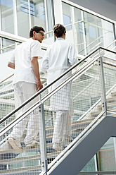 Deutschland, Bayern, Diessen am Ammersee, Zwei junge Ärzte gehen und diskutieren auf einer Treppe - JRF000229