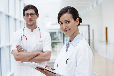 Germany, Bavaria, Diessen am Ammersee, Two young doctors with clip board and stethoscope, smiling - JRF000232