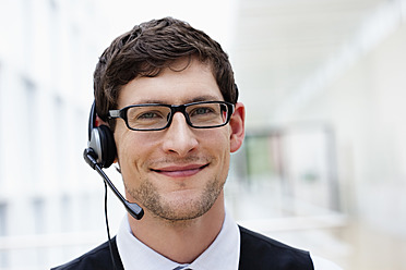 Deutschland, Bayern, Diessen am Ammersee, Nahaufnahme eines Geschäftsmannes mit Headset, lächelnd, Portrait - JRF000269