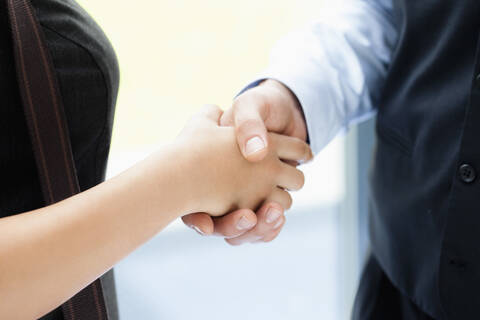 Germany, Bavaria, Diessen am Ammersee, Close up of young business people shaking hands stock photo