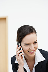 Deutschland, Bayern, Diessen am Ammersee, Junge Geschäftsfrau im Gespräch mit Mobiltelefon, lächelnd - JRF000284