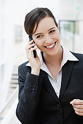 Germany, Bavaria, Diessen am Ammersee, Young businesswoman talking on mobile phone, smiling, portrait - JRF000291