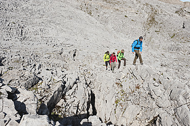 Austria, Kleinwalsertal, Group of people hiking on rocky mountain trail - MIRF000217