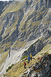 Austria, Kleinwalsertal, Group of people hiking on rocky mountain trail - MIRF000220