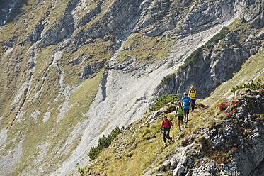 Austria, Kleinwalsertal, Group of people hiking on rocky mountain trail - MIRF000222