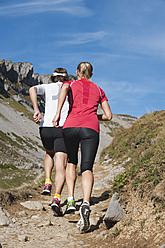Österreich, Kleinwalsertal, Mann und Frau laufen auf Bergpfad - MIRF000228
