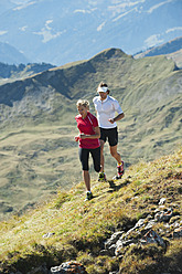 Österreich, Kleinwalsertal, Mann und Frau laufen auf Bergpfad - MIRF000230