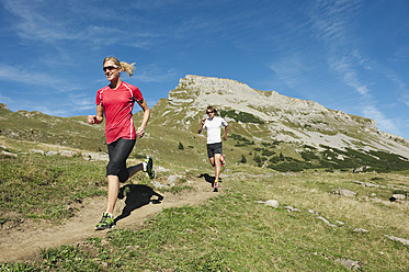 Österreich, Kleinwalsertal, Mann und Frau laufen auf Bergpfad - MIRF000233