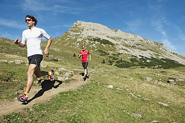 Österreich, Kleinwalsertal, Mann und Frau laufen auf Bergpfad - MIRF000234