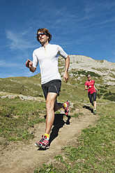 Österreich, Kleinwalsertal, Mann und Frau laufen auf Bergpfad - MIRF000235
