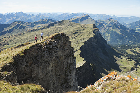 Österreich, Kleinwalsertal, Mann und Frau beim Trailrunning am Felsen - MIRF000236