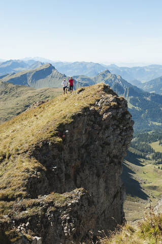 Österreich, Kleinwalsertal, Mann und Frau beim Trailrunning am Felsen, lizenzfreies Stockfoto