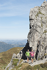 Österreich, Kleinwalsertal, Mann und Frau wandern in der Nähe von Felsen am Berg - MIRF000239