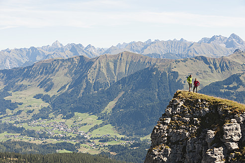 Österreich, Kleinwalsertal, Mann und Frau wandern am Rande eines Felsens - MIRF000244