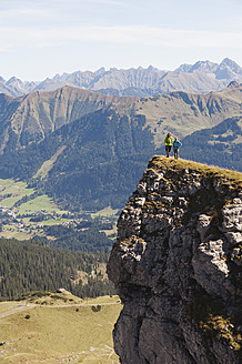 Österreich, Kleinwalsertal, Mann und Frau wandern am Rande eines Felsens - MIRF000245