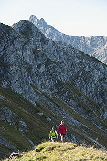 Österreich, Kleinwalsertal, Mann und Frau wandern auf Bergpfad - MIRF000246