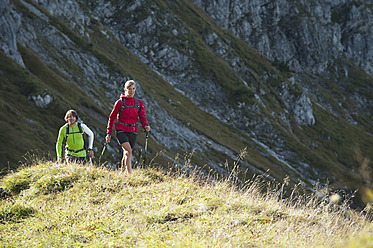 Austria, Kleinwalsertal, Man and woman hiking on mountain trail - MIRF000247