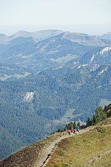 Austria, Kleinwalsertal, Man and woman hiking on mountain trail - MIRF000250