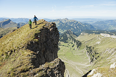 Österreich, Kleinwalsertal, Mann und Frau wandern am Rande eines Felsens - MIRF000253