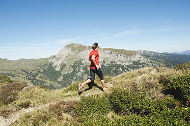 Österreich, Kleinwalsertal, Mittlerer Erwachsener Mann läuft auf Bergpfad - MIRF000263
