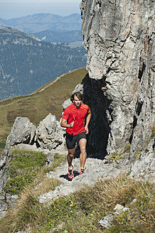 Österreich, Kleinwalsertal, Mittlerer Erwachsener Mann läuft auf Bergpfad in der Nähe von Felsen - MIRF000264