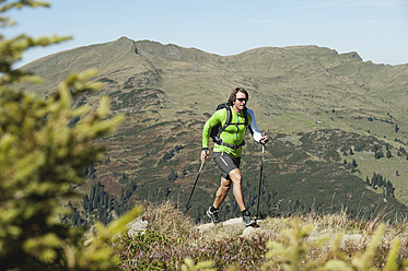 Österreich, Kleinwalsertal, Mittlerer erwachsener Mann beim Wandern auf einem Bergpfad - MIRF000267