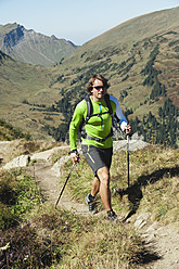 Österreich, Kleinwalsertal, Mittlerer erwachsener Mann beim Wandern auf einem Bergpfad - MIRF000269