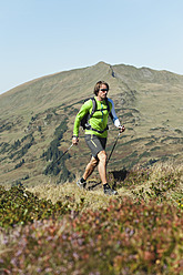 Österreich, Kleinwalsertal, Mittlerer erwachsener Mann beim Wandern auf einem Bergpfad - MIRF000270