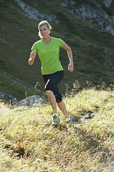 Österreich, Kleinwalsertal, Junge Frau läuft auf Bergpfad - MIRF000271