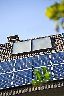 Germany, Cologne, House rooftops with different of solar panels - TSF000307