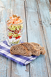 Nahaufnahme von Salat mit Garnelen und Walnüssen in einem Glas mit Brotscheiben auf einer Serviette - MAEF003559