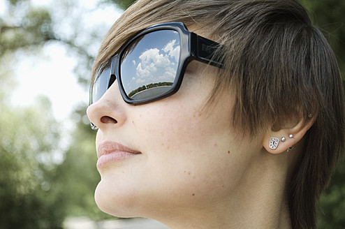 Deutschland, Rheinland, Junge Frau mit Sonnenbrille, Nahaufnahme - LFOF000120