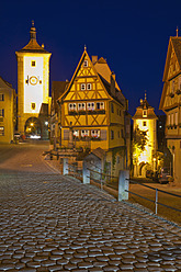 Germany, Bavaria, Franconia, Rothenburg ob der Tauber, View of Ploenlein, frame houses and Siebersturm tower with cobblestone street in foreground - WDF000997