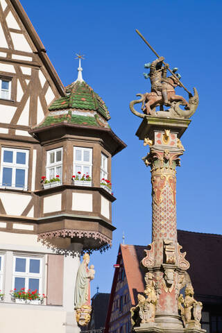 Deutschland, Bayern, Franken, Rothenburg ob der Tauber, Ansicht von Georgsbrunnen mit Fachwerkhaus am Marktplatz, lizenzfreies Stockfoto