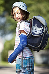 Deutschland, Bayern, Verwundetes Mädchen mit Arm in Gips auf dem Weg zur Schule - MAEF003585