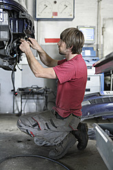 Germany, Ebenhausen, Mechatronic technician working in car garage - TCF001613