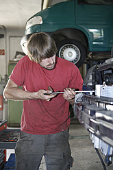 Germany, Ebenhausen, Mechatronic technician working in car garage - TCF001616